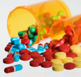 colorful pills spilled out of orange plastic containers